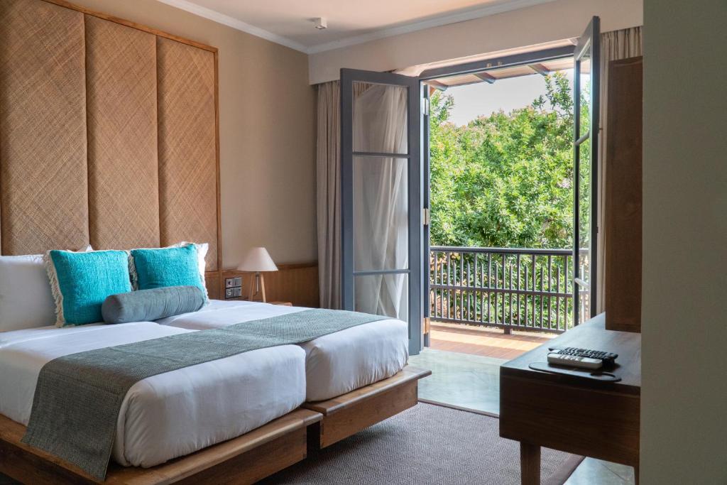 a bedroom with a large bed and a sliding glass door at The Merchant in Galle