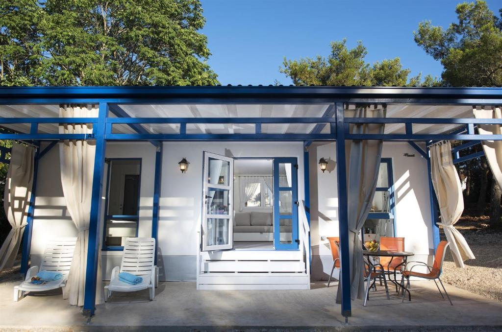 a shed with a blue roof and a table and chairs at Port 9 Mobile Homes by Aminess in Korčula
