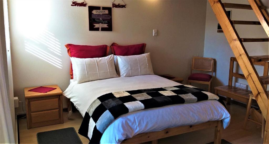 a bedroom with a bed with a black and white comforter at Kozmos in Clarens
