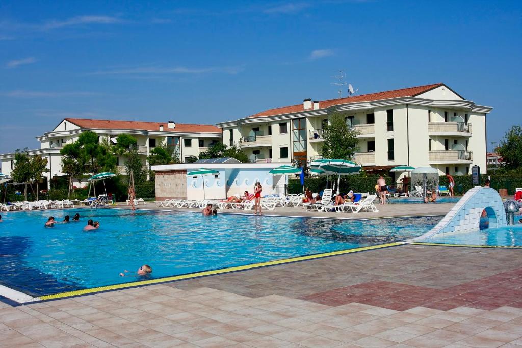 una piscina con gente en el agua y un tobogán en TIGLI Lido Altanea, en Caorle