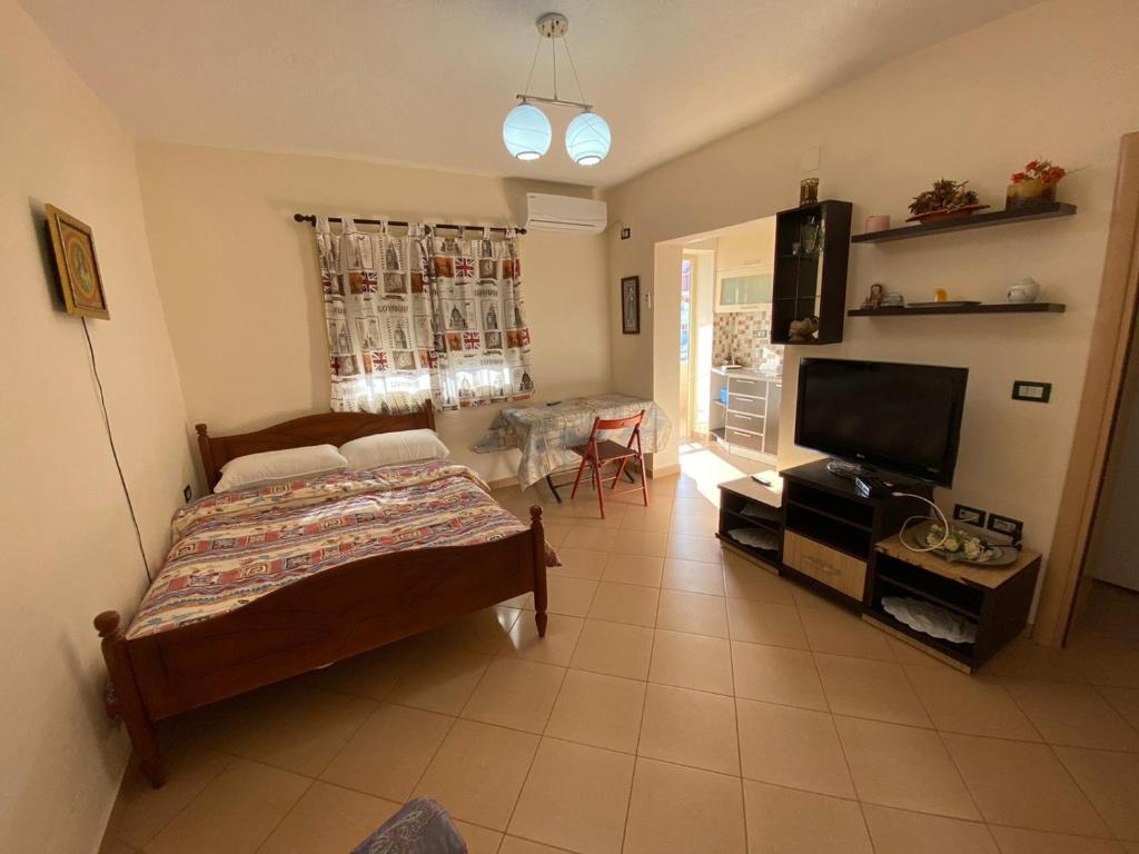 a bedroom with a bed and a television and a table at 88 Apartment Himare in Himare