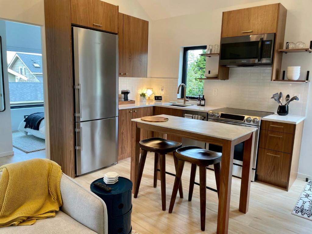 a kitchen with a stainless steel refrigerator and a table at Greenwood Getaway in Seattle