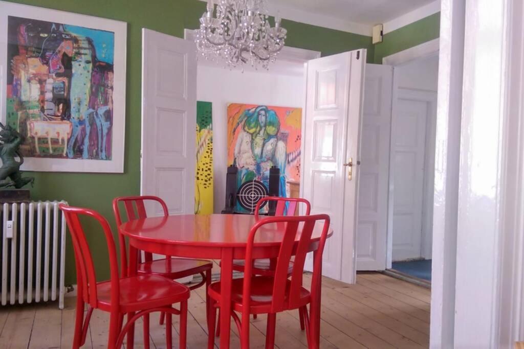 a dining room with a red table and red chairs at The nicest house with internet in Rudkøbing