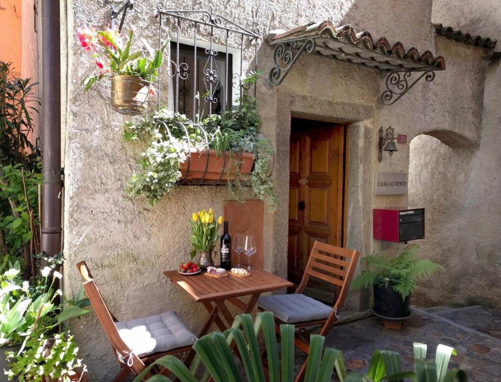eine kleine Terrasse mit einem Tisch, Stühlen und einem Fenster in der Unterkunft Casa al Vento in Bidogno