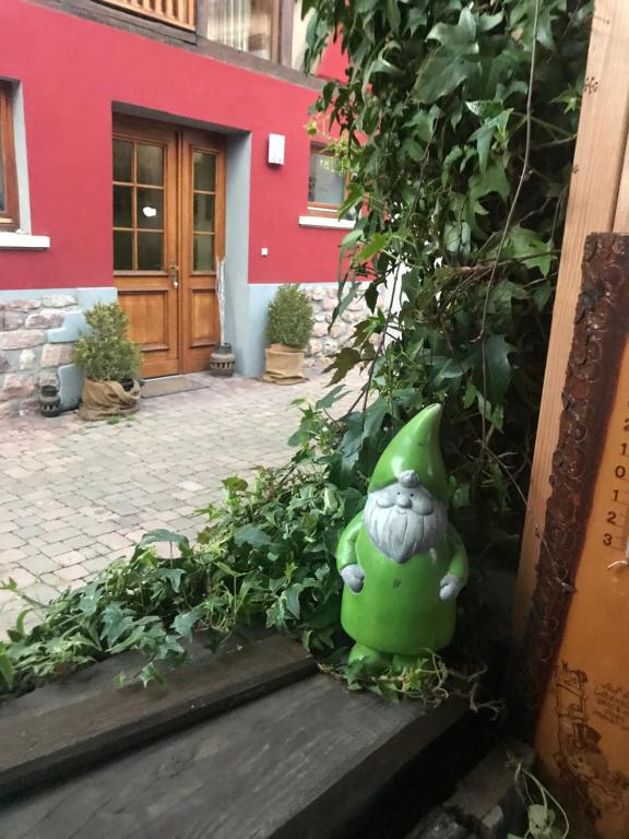 um vaso verde sentado nos degraus de um edifício em La maison rouge em Ostheim
