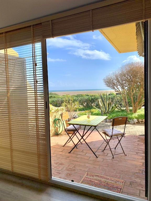 Elle offre une vue sur une terrasse avec une table et des chaises. dans l'établissement Maison de la Mer, à Port-Leucate