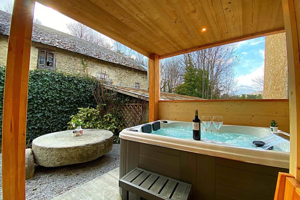 a jacuzzi tub with a bottle of wine at Gîte avec jacuzzi privatif in Crots