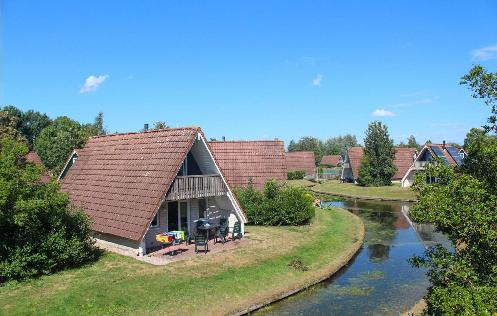 une maison avec un toit à côté d'une rivière dans l'établissement Nice Home In Gramsbergen With Indoor Swimming Pool, à Gramsbergen