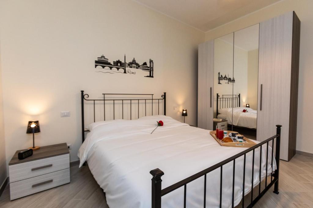 ein Schlafzimmer mit einem großen weißen Bett und einem Spiegel in der Unterkunft [Near S.GIOVANNI/METRO C *****] Big New Apartment in Rom