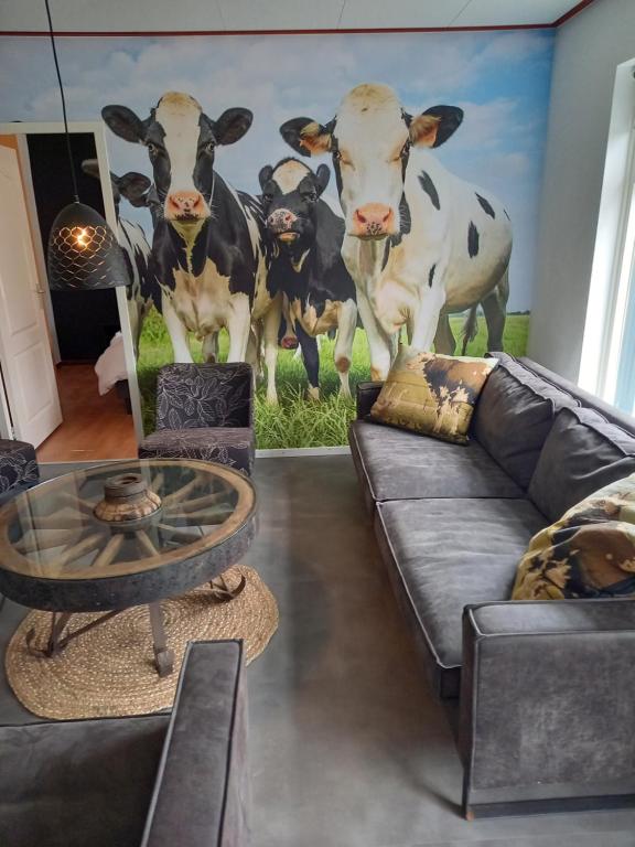 a living room with a mural of cows on the wall at Aan 't weitje in Ermelo