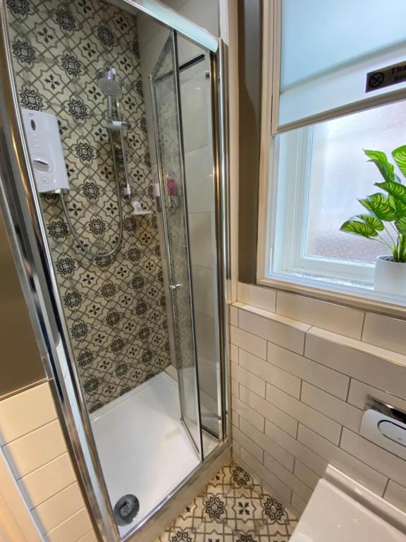 a shower with a glass door in a bathroom at Galtres Chambers Apartment Coppergate in York