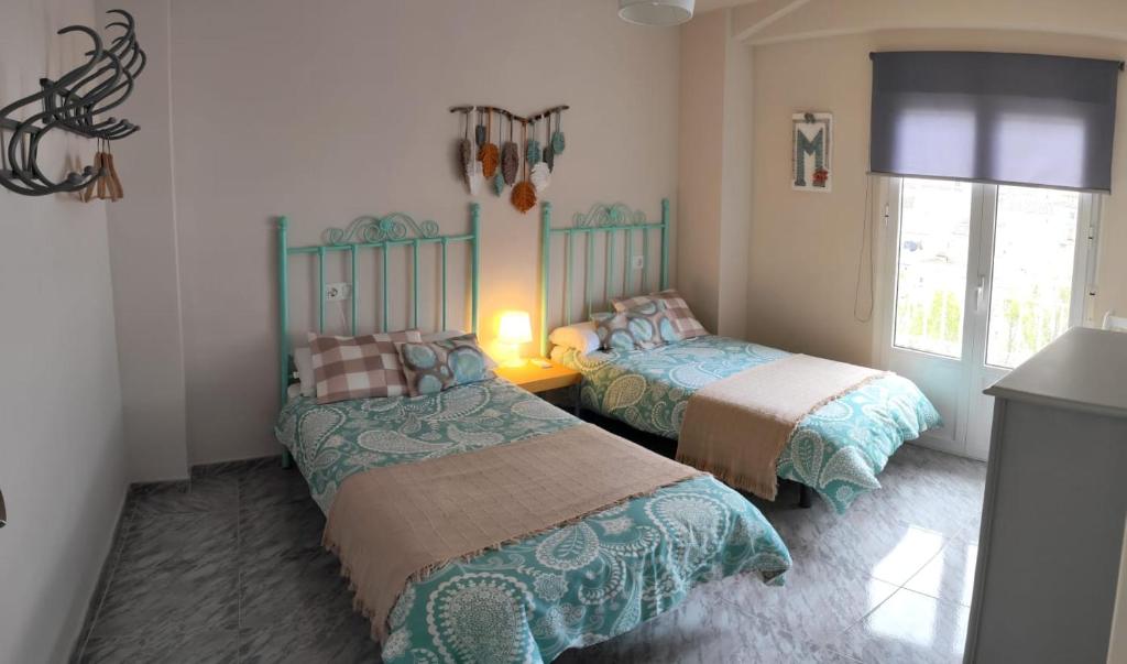a bedroom with two beds and a window at La Casa De Mariana in Cazorla