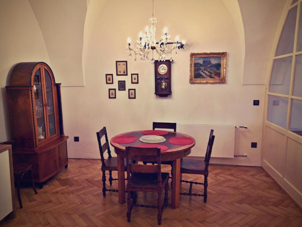 a dining room with a table and chairs and a clock at Apartmány na Trojmezí, byt Leopold in Slavonice