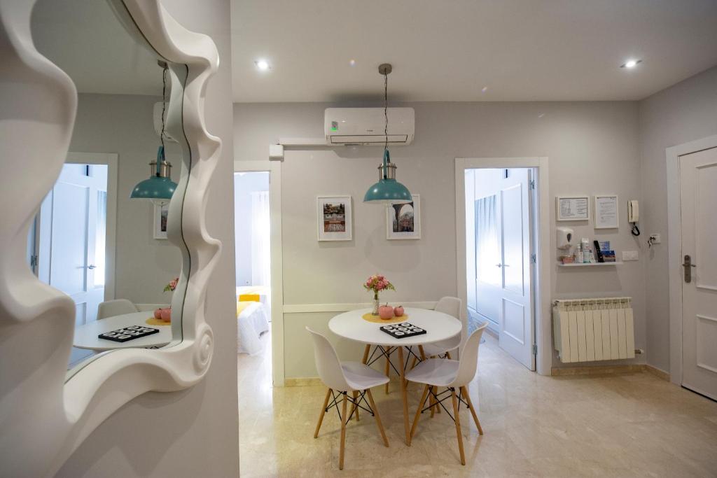 Hotel MAJESTUOSA ALHAMBRA Nuevo apartamento, a dining room with a white table and chairs at MAJESTUOSA ALHAMBRA Nuevo apartamento in Granada