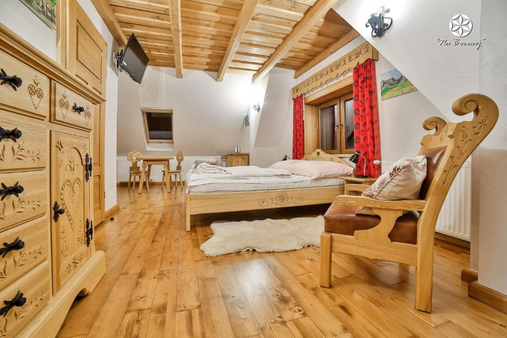 1 dormitorio con 1 cama y 1 silla en Agroturystyka "Na Borowej" en Czarny Dunajec