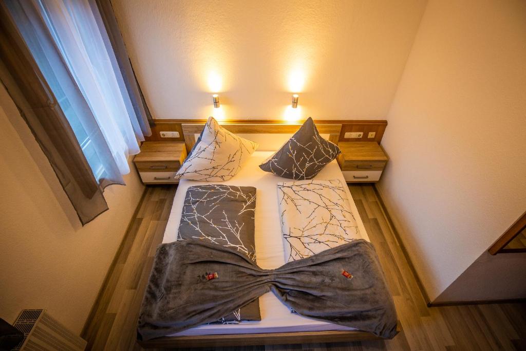 a bedroom with a bed with a bow tie on it at Dorfwirt Pfronten in Pfronten