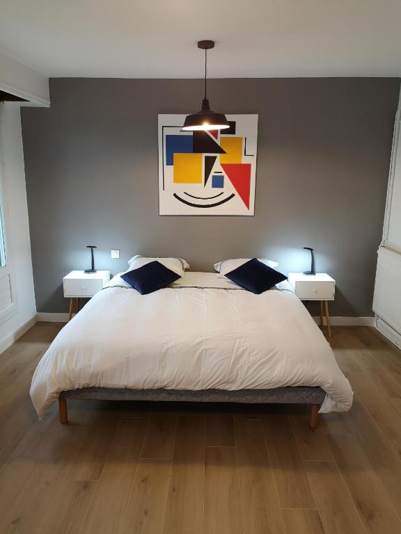 une chambre avec un grand lit avec deux tables de nuit dans l'établissement Appartement tout confort 2 chbres - 72m2 - avec terrasse et vue Pyrénées, à Pau