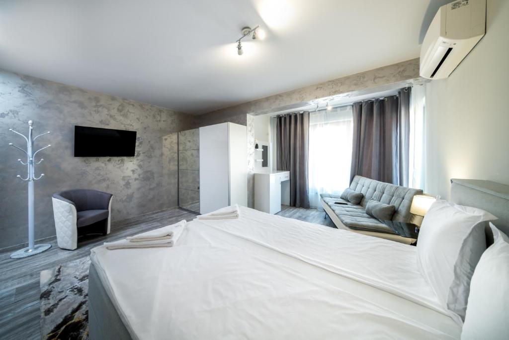 Habitación de hotel con cama grande y sofá en Boutique Guest House"Ruvan", en Burgas