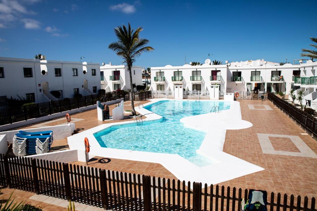 a swimming pool in the middle of a resort at Grandes Playas in Corralejo