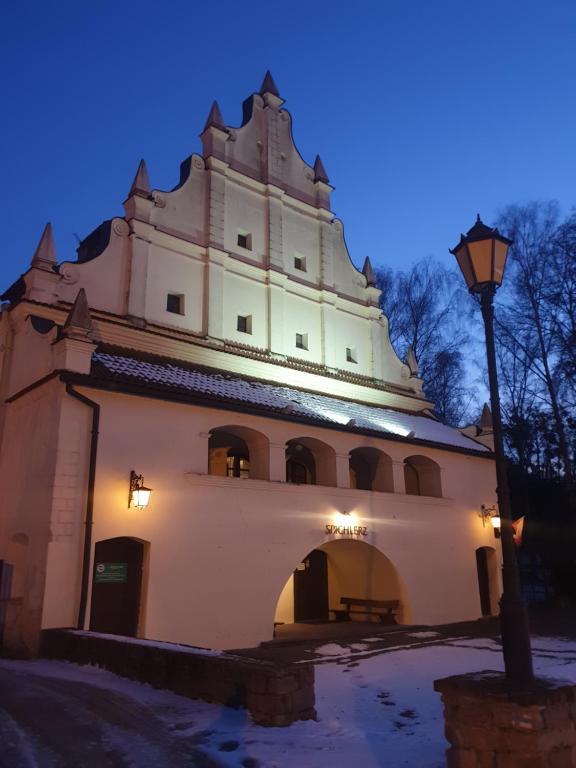 a large white building with a street light next to it at Spichlerz na Krakowskiej in Kazimierz Dolny