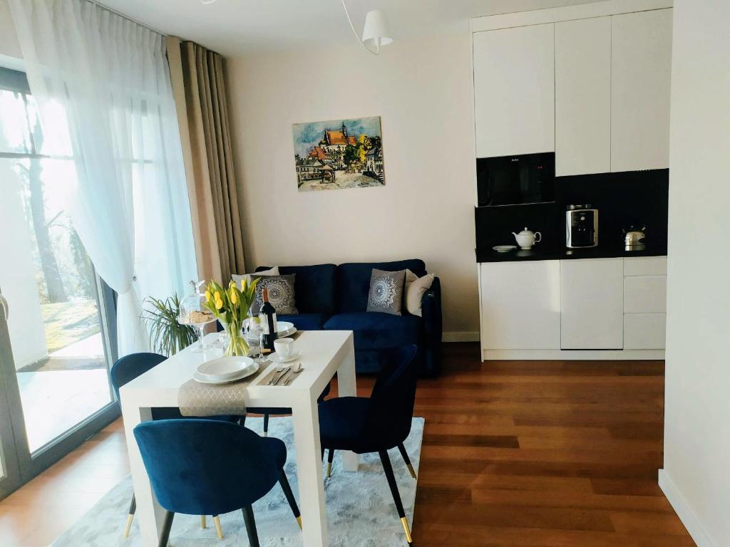 uma sala de estar com uma mesa e um sofá azul em Apartamenty RÓŻANA 2 em Nałęczów