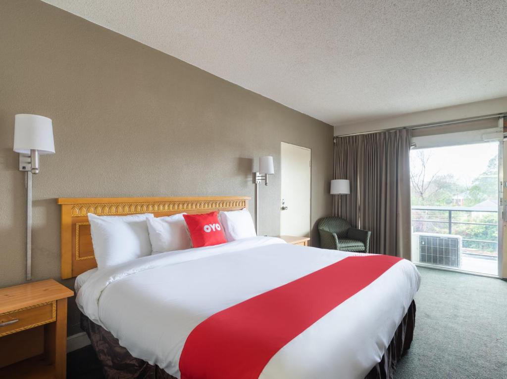 een hotelkamer met een groot bed en een raam bij OYO Hotel Sumter SC Downtown in Sumter