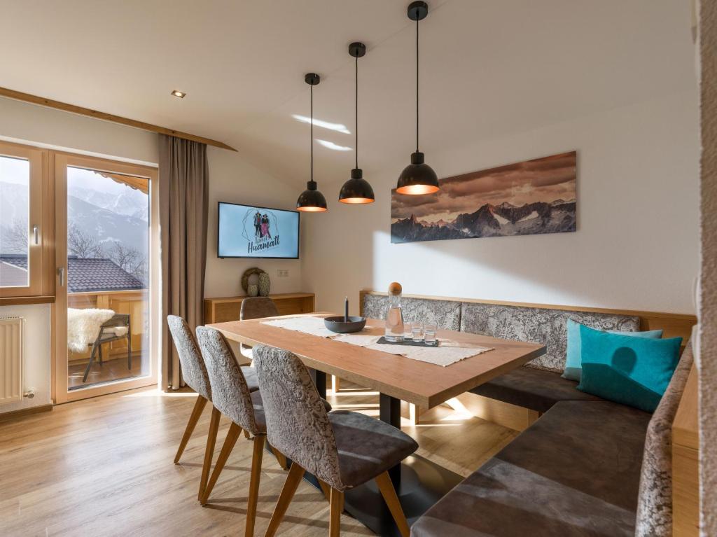 a dining room with a wooden table and chairs at Apart Huamatl in Ramsau im Zillertal