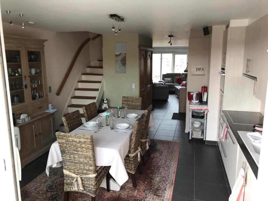 een eetkamer met een tafel en een keuken bij Duplex Blankenberge in Blankenberge