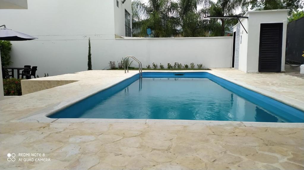 una piscina con agua azul en un patio trasero en Villas del Guali - Piscina Privada, en Santa Fe de Antioquia