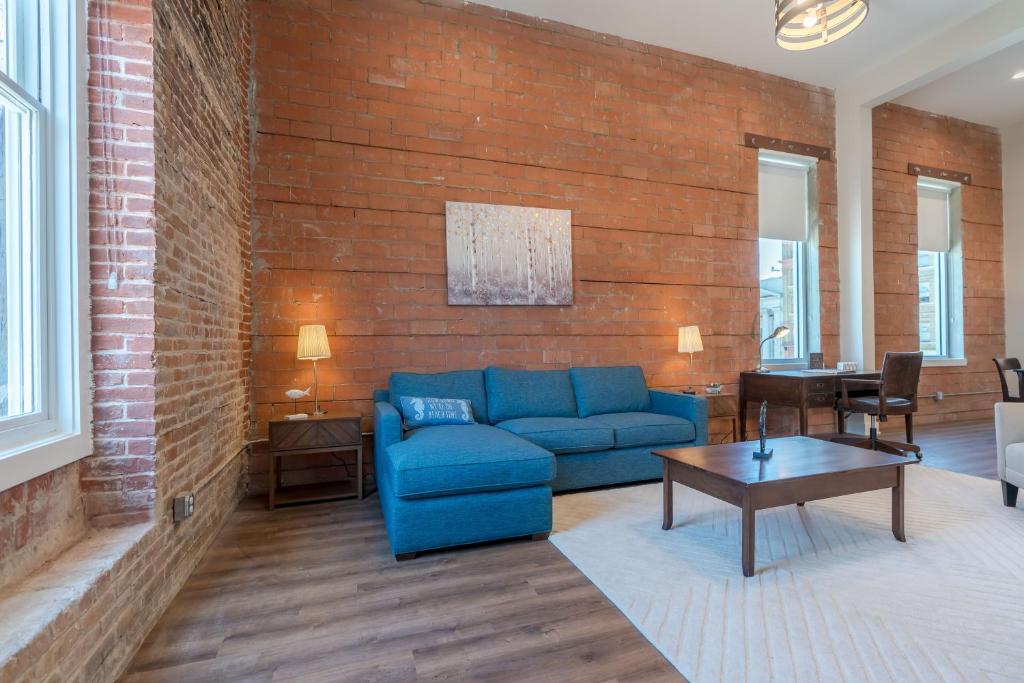 a living room with a blue couch and a brick wall at Meilleur in Galveston