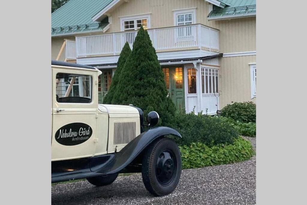an old truck parked in front of a house at En oas nära Birsta in Sundsvall