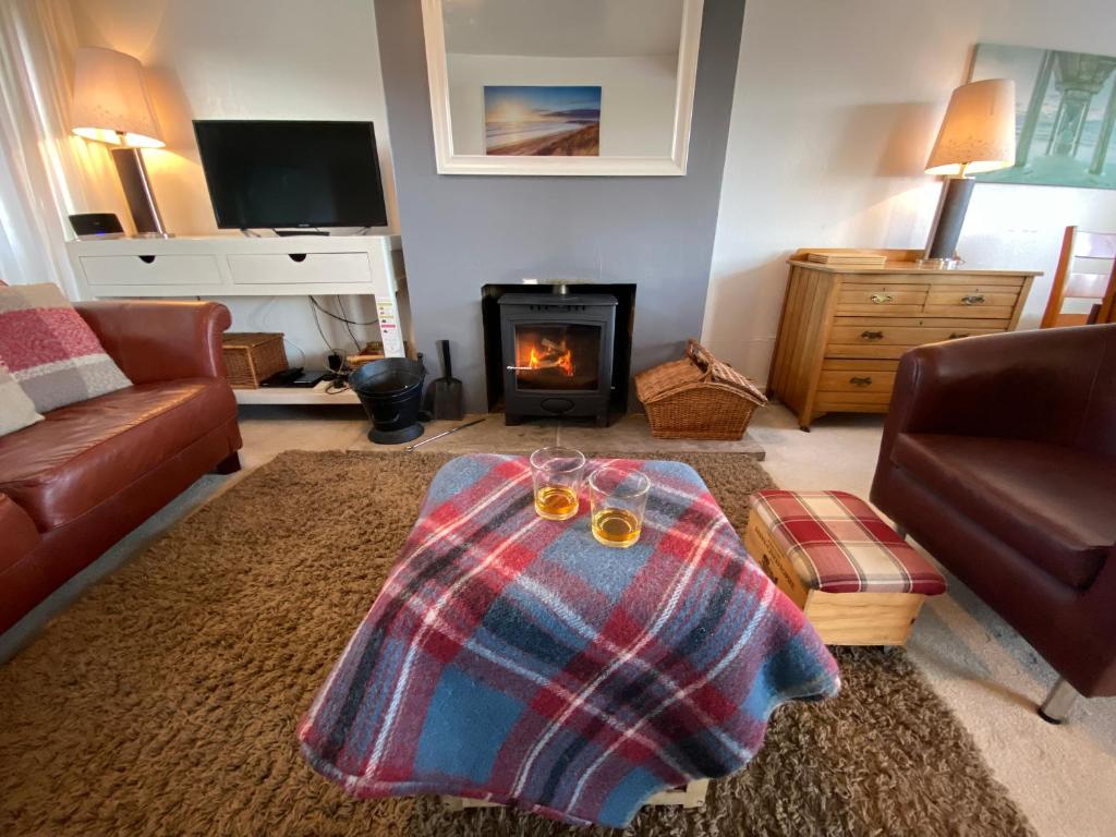 sala de estar con sofá y chimenea en Beach View Cottage, en Isle of Gigha