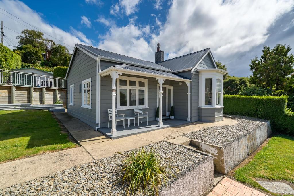a small grey house with a garden at Magic in Mornington in Dunedin