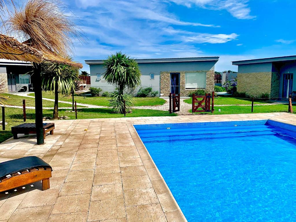 a swimming pool in front of a house at Riviera del Sur - Apart hotel in Miramar