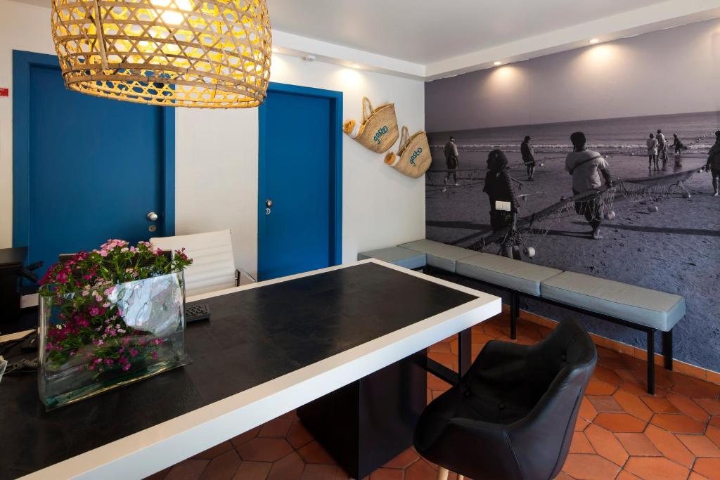 a dining room with a table and chairs and a painting at Costa d'Oiro Ambiance Village in Lagos
