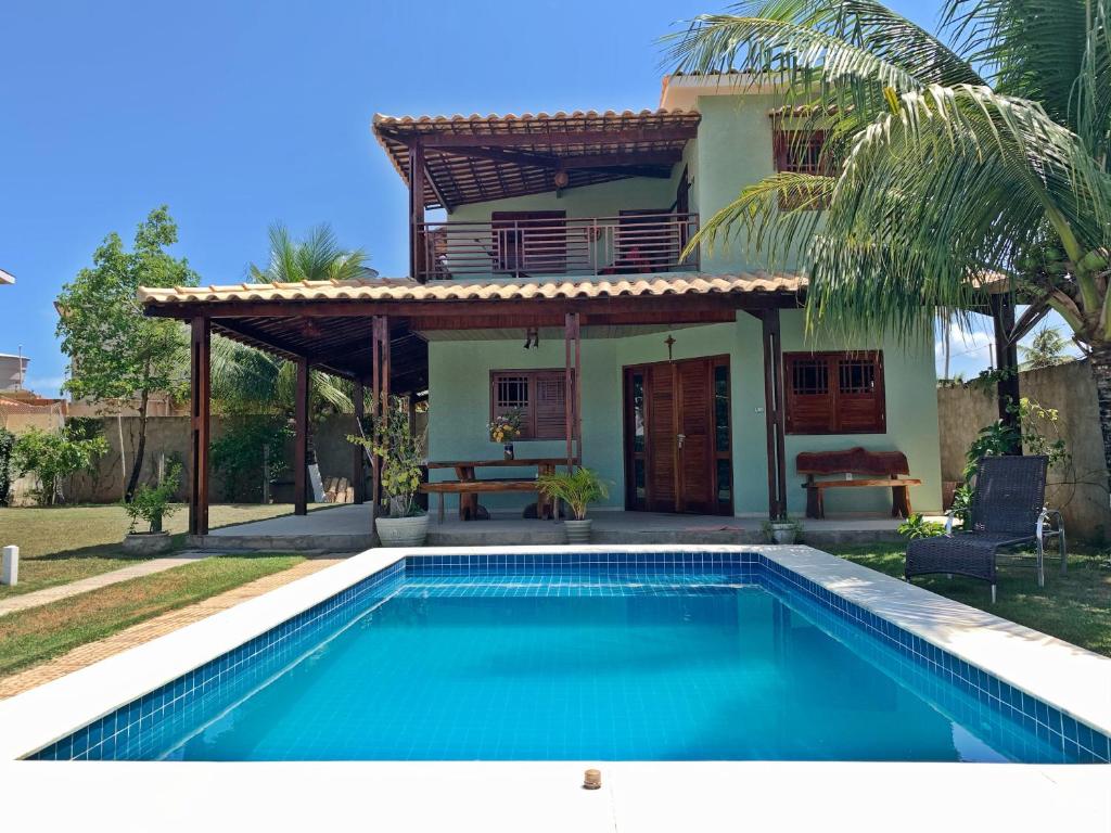 a villa with a swimming pool in front of a house at Casa em Peroba/Maragogi in Maragogi