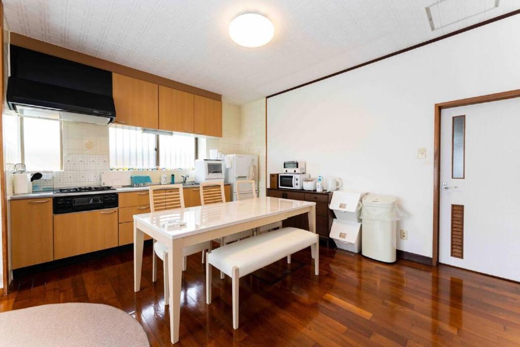 cocina con mesa y sillas en una habitación en Mizunowa B035, en Nago