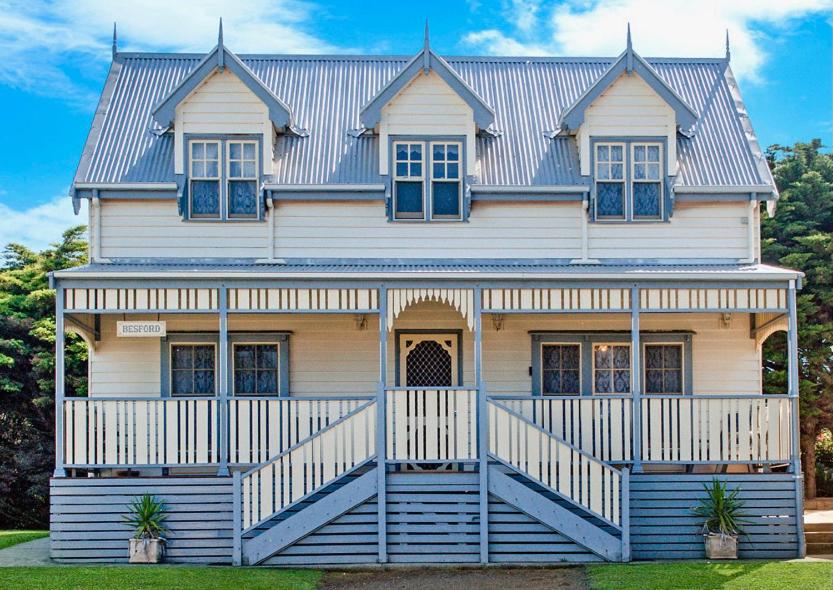 une grande maison blanche avec un toit bleu dans l'établissement Sails - elegant, spacious beach villa, à Port Fairy