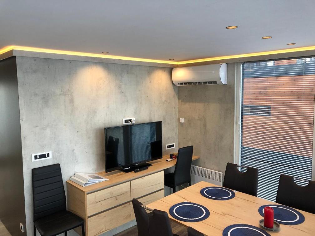 a meeting room with a table with chairs and a television at MarinaVilla in Nykøbing Falster
