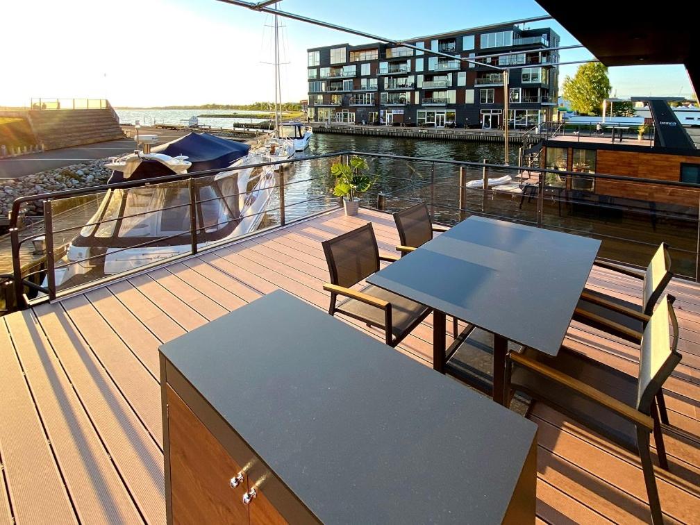 a balcony with a table and chairs on a boat at MarinaVilla in Nykøbing Falster