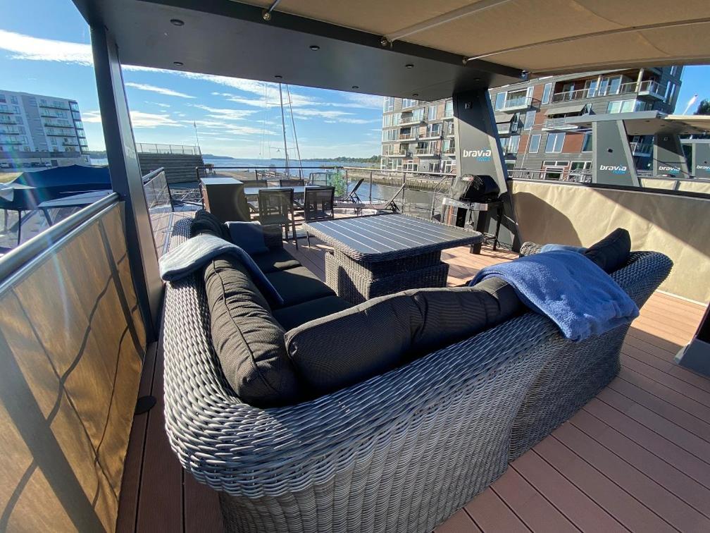 a wicker couch sitting on top of a balcony at MarinaVilla in Nykøbing Falster