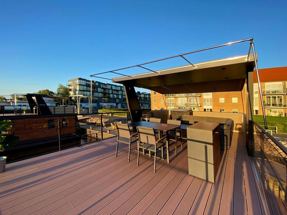 a deck with a table and chairs on a building at MarinaVilla in Nykøbing Falster