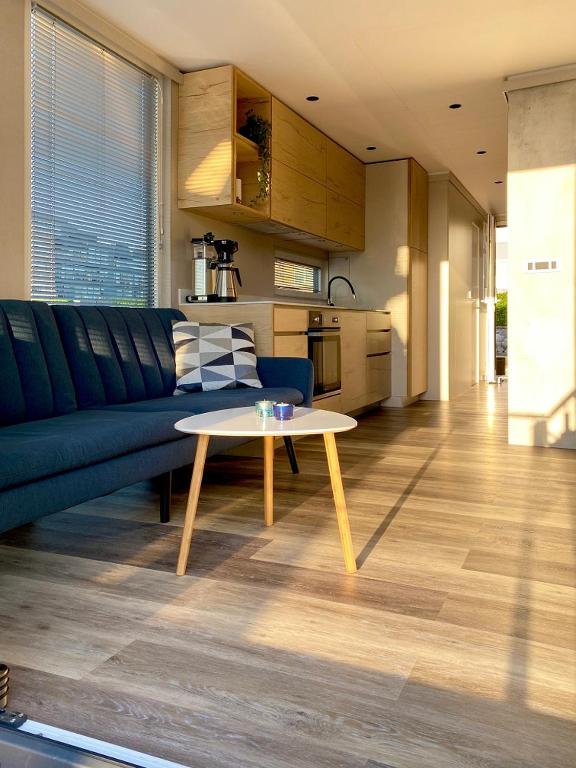 a living room with a blue couch and a table at MarinaVilla in Nykøbing Falster