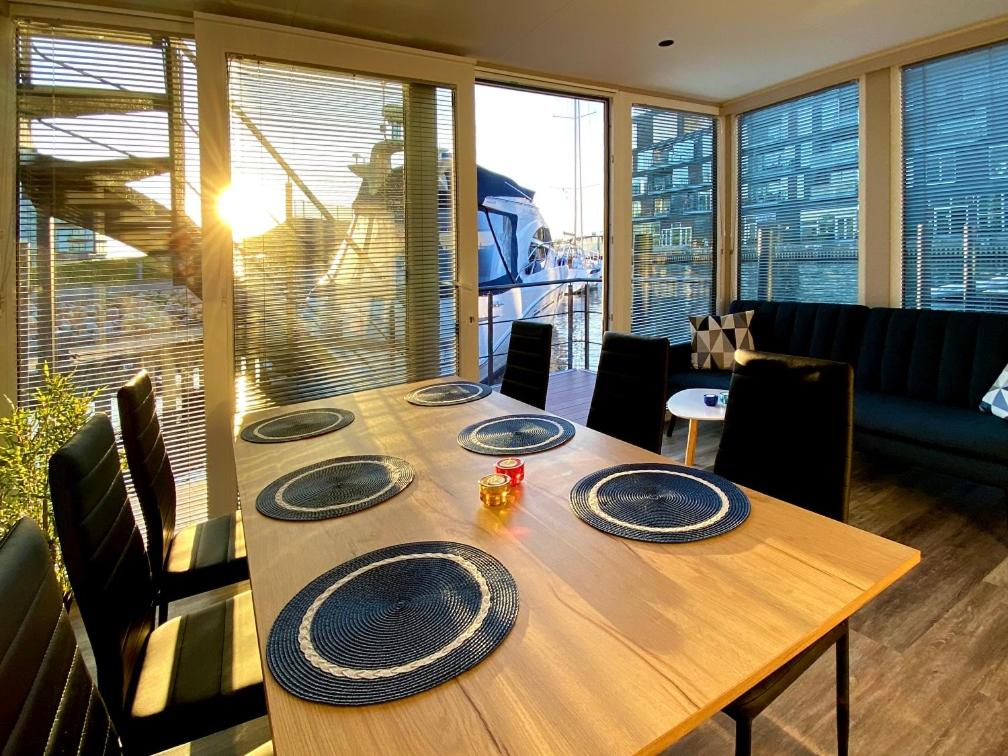 a wooden table with plates on it in a living room at MarinaVilla in Nykøbing Falster