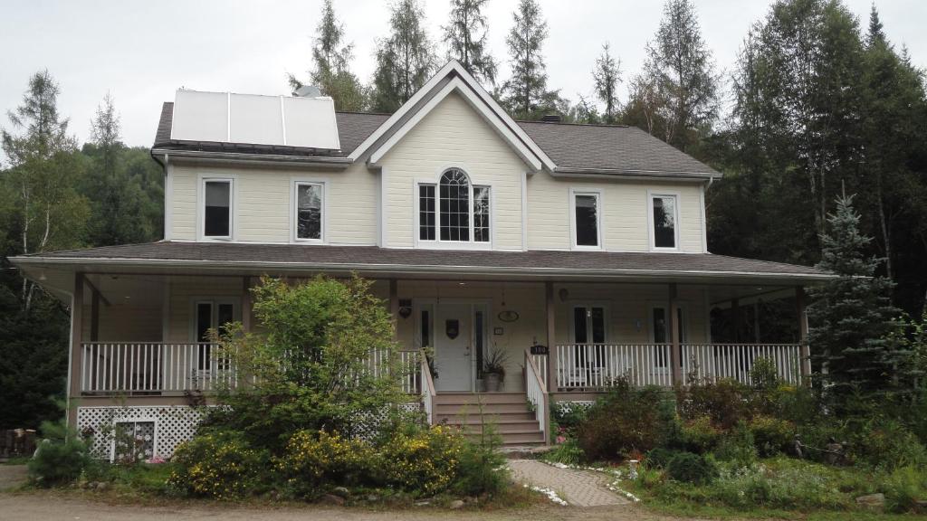 蒙特朗布朗的住宿－Gîte Crystal Inn，一座白色的房子,上面装有太阳能电池板