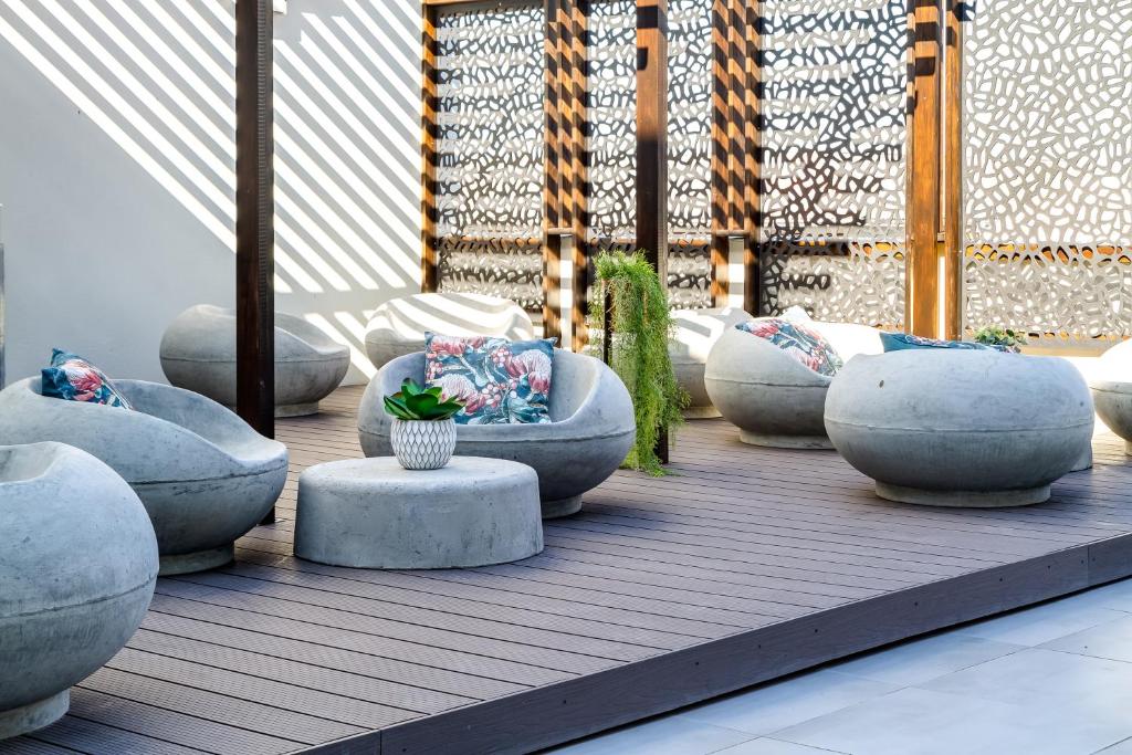 a patio with a bunch of pillows and benches at WINK Aparthotel Eaton Square in Cape Town