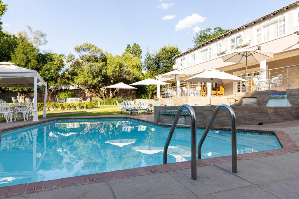 a swimming pool in front of a hotel at Dikalo Highston in Johannesburg