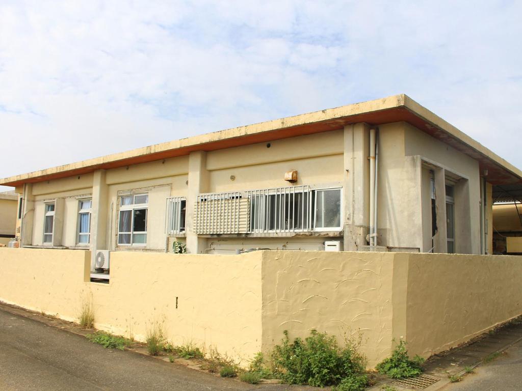 a house with a fence in front of it at Guest House Miyakojima in Miyako-jima
