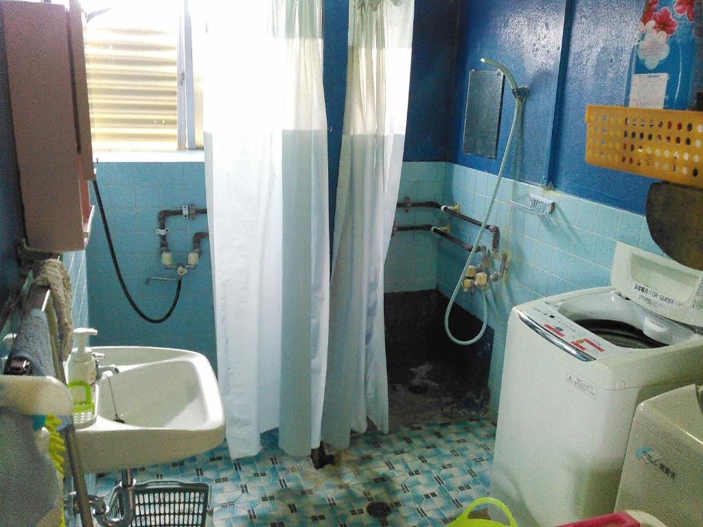 a bathroom with a sink and a toilet and a shower at Guest House Miyakojima in Miyako-jima