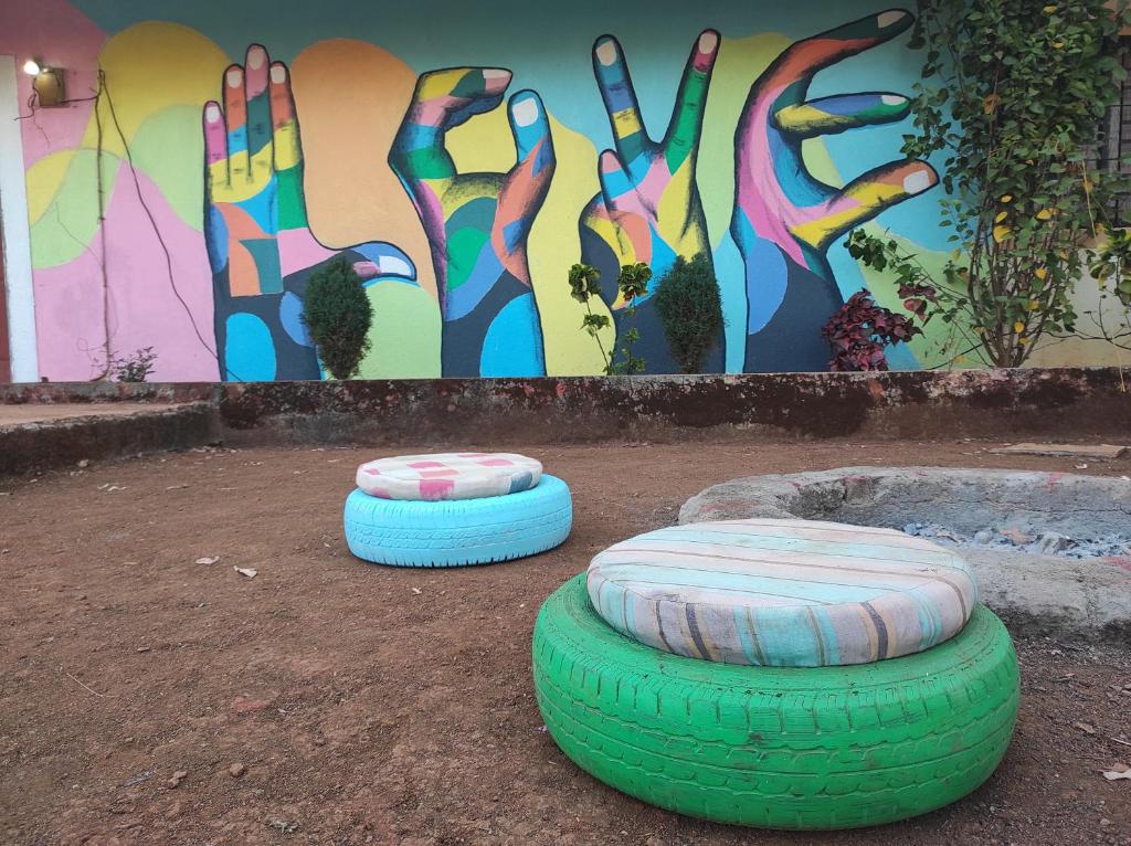 馬哈巴萊斯赫瓦爾的住宿－Echo Villa，两辆轮胎坐在墙上的泥土上